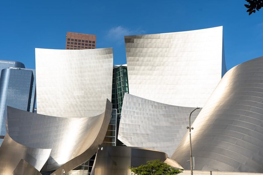 Stainless steel facade of a Frank Gehry building under blue sky