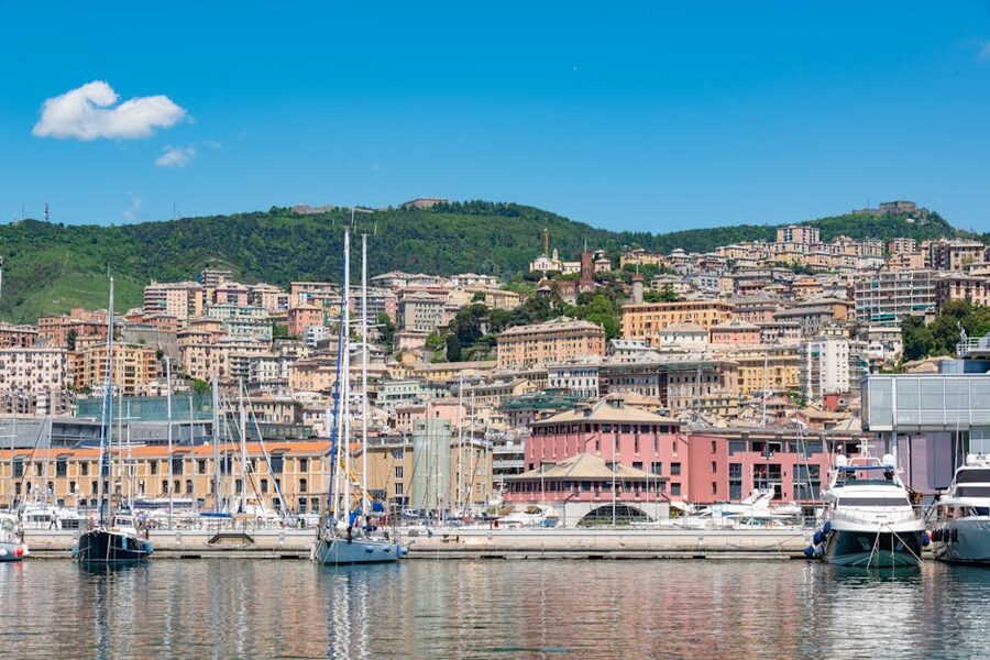 Genoa marina with sailboats and historic townscape on the hillside
