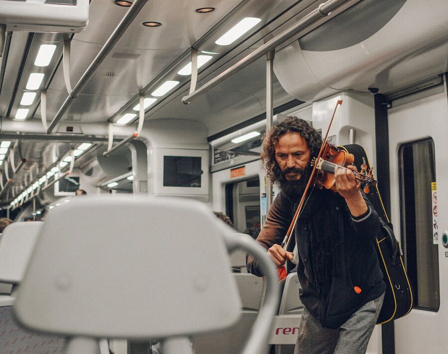 Violinist busker playing inside Barcelona metro train