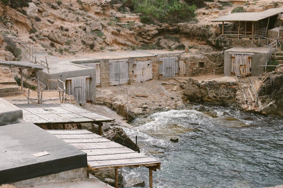 Old rustic fishermens huts by the rocky coastline in Ibiza