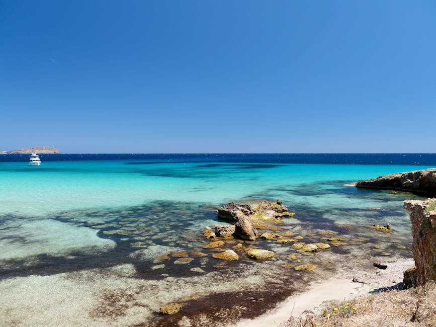 Ibiza turquoise waters and rocky coastline under a clear sky