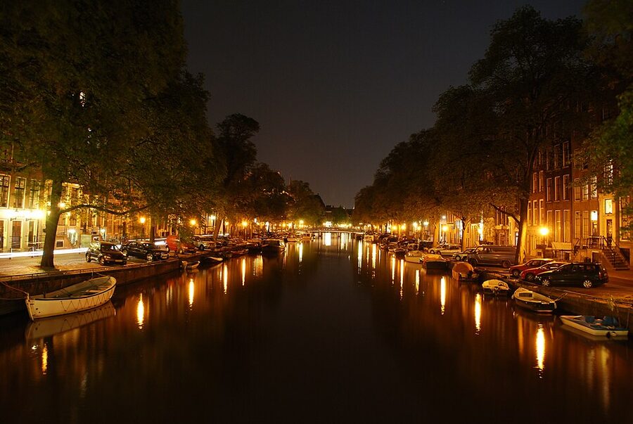 Amsterdam canal at night with lit historic gable houses