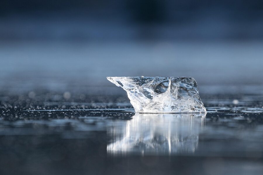 Clear block of frozen ice with light filtering through