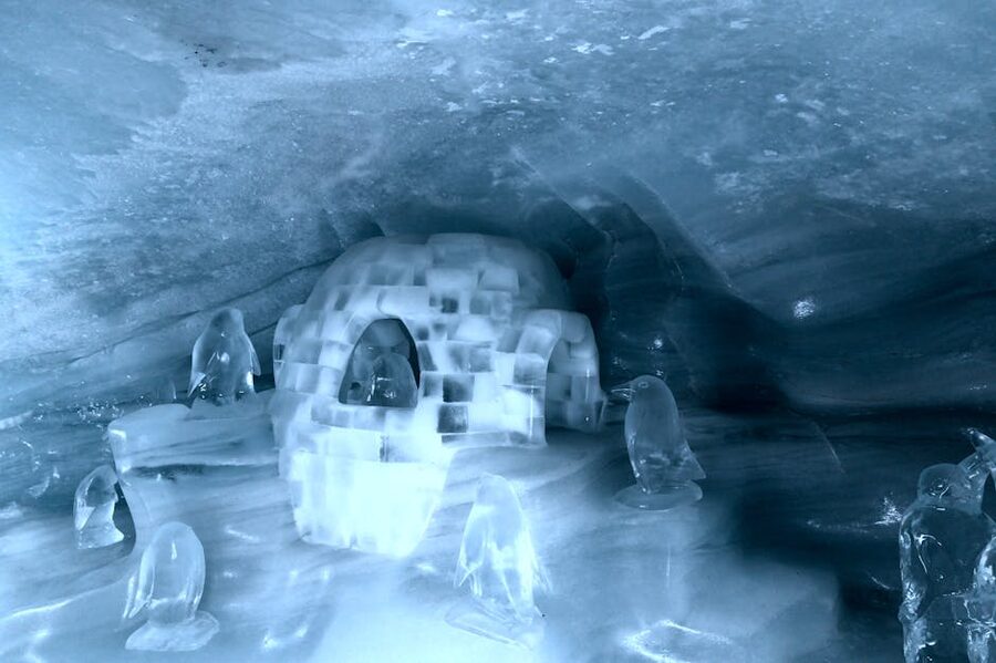 Carved ice cave passage with sculpted figures