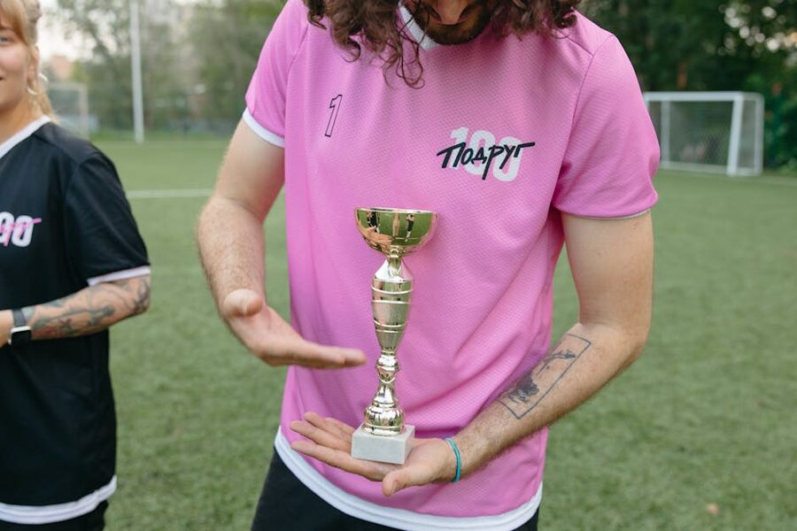 Soccer player in jersey holding a trophy