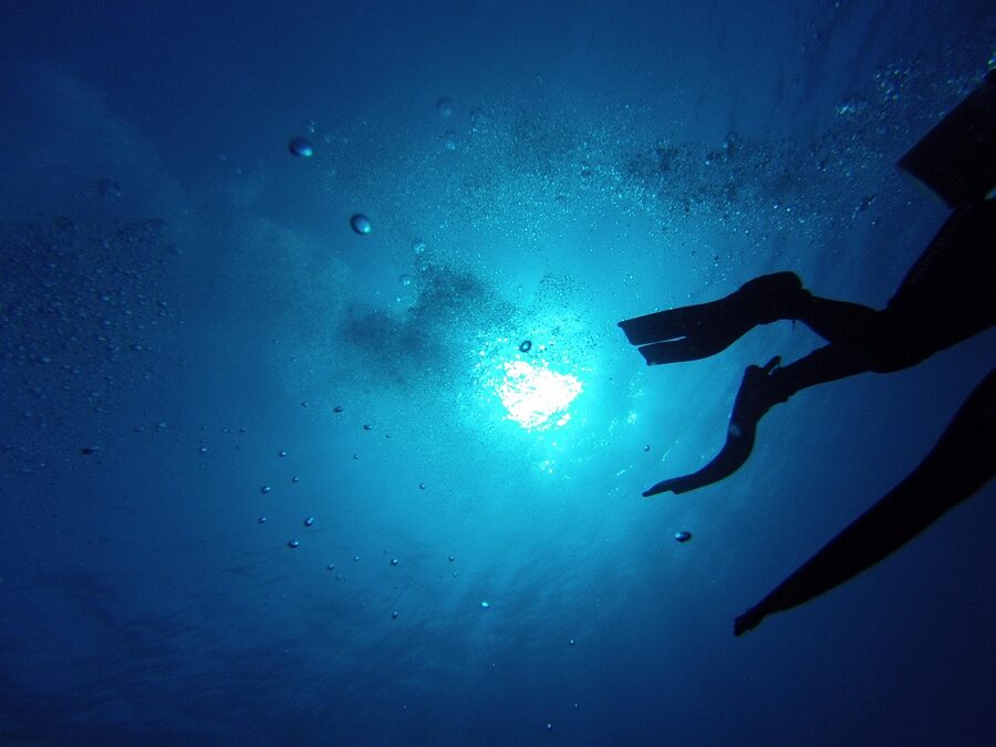Diving fins kicking through clear water