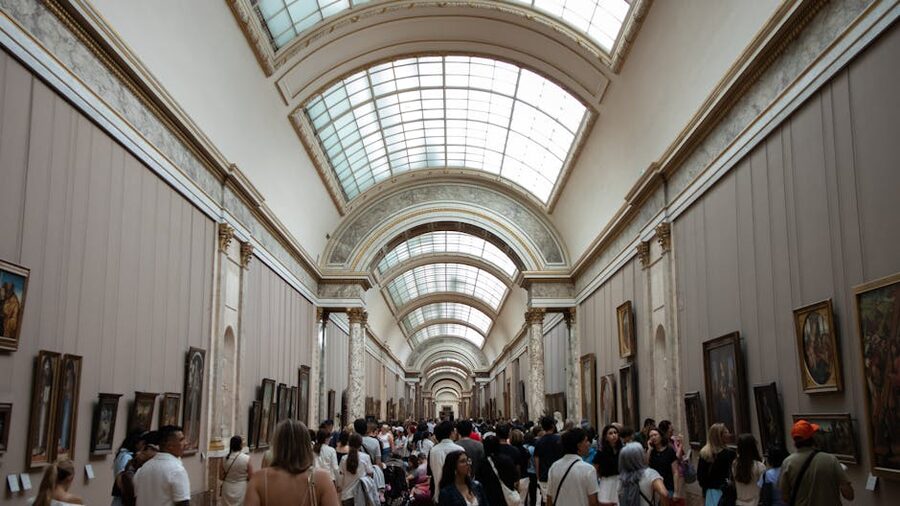 Louvre busy corridor with paintings Paris