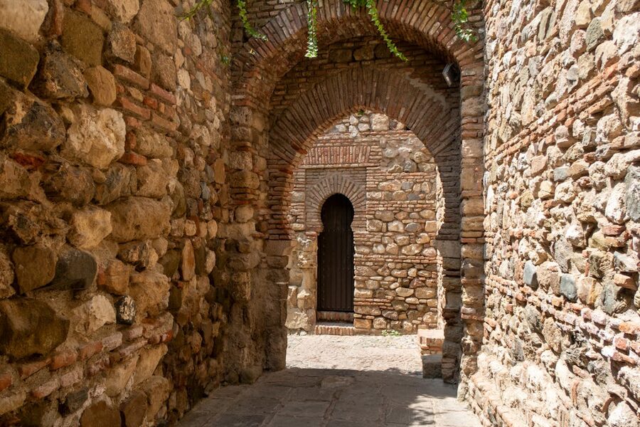 Alcazaba Malaga sunlit stone arch passage with horseshoe arches