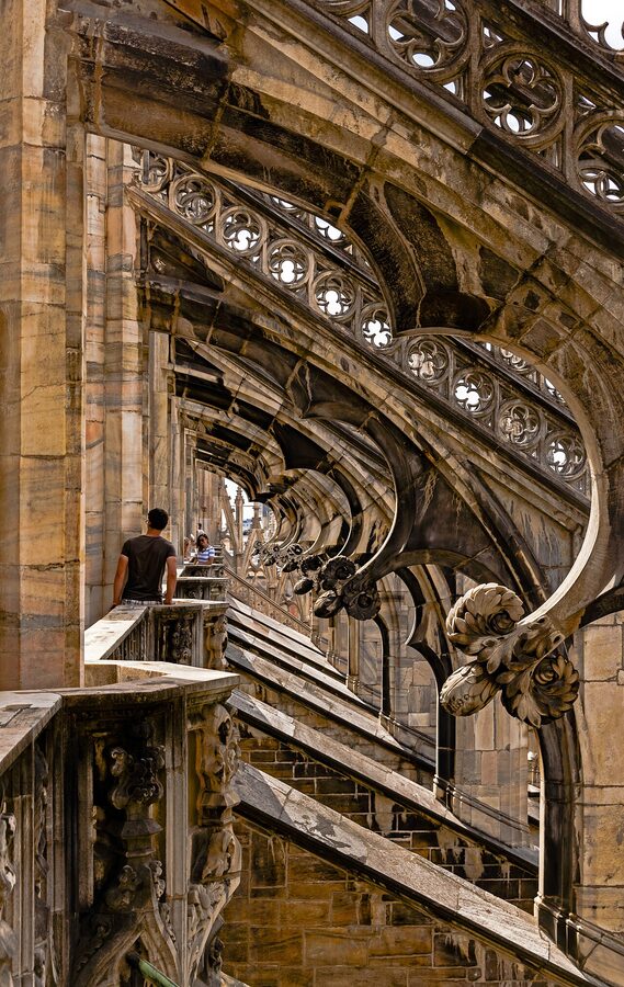 Tourists looking at flying buttresses on Milan Duomo roof