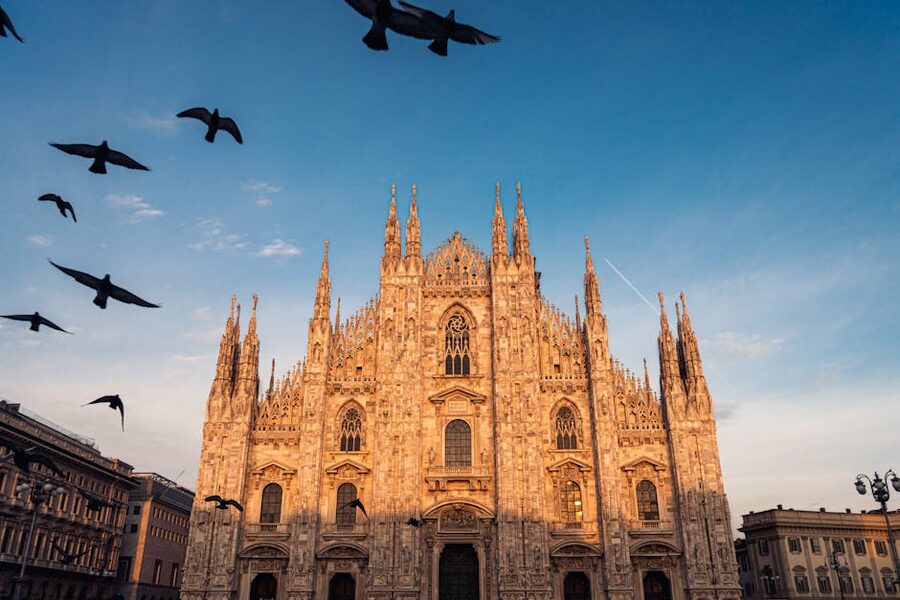 Milan Duomo at sunset with birds flying past spires