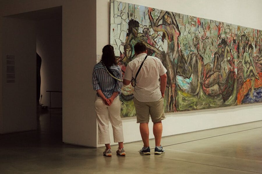 Two visitors viewing abstract painting in modern art museum