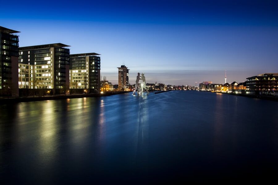 Molecule Man sculpture on the Spree at night Berlin skyline