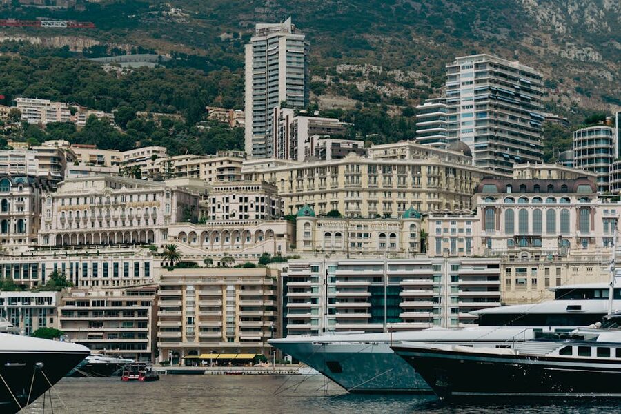 Monaco's Port Hercule with luxury yachts and an arch sculpture