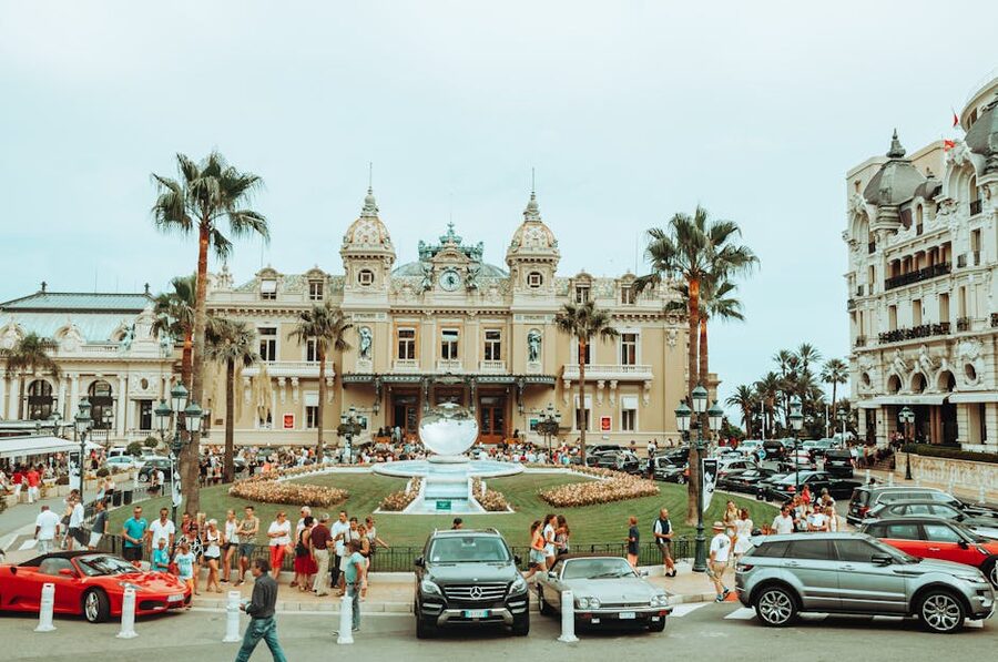 The Monte Carlo Casino entrance with luxury cars and visitors on Place du Casino