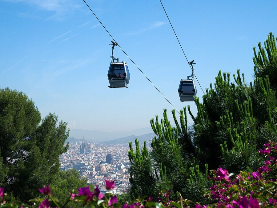 Telefèric de Montjuïc cabin climbing above the trees of Montjuïc hill