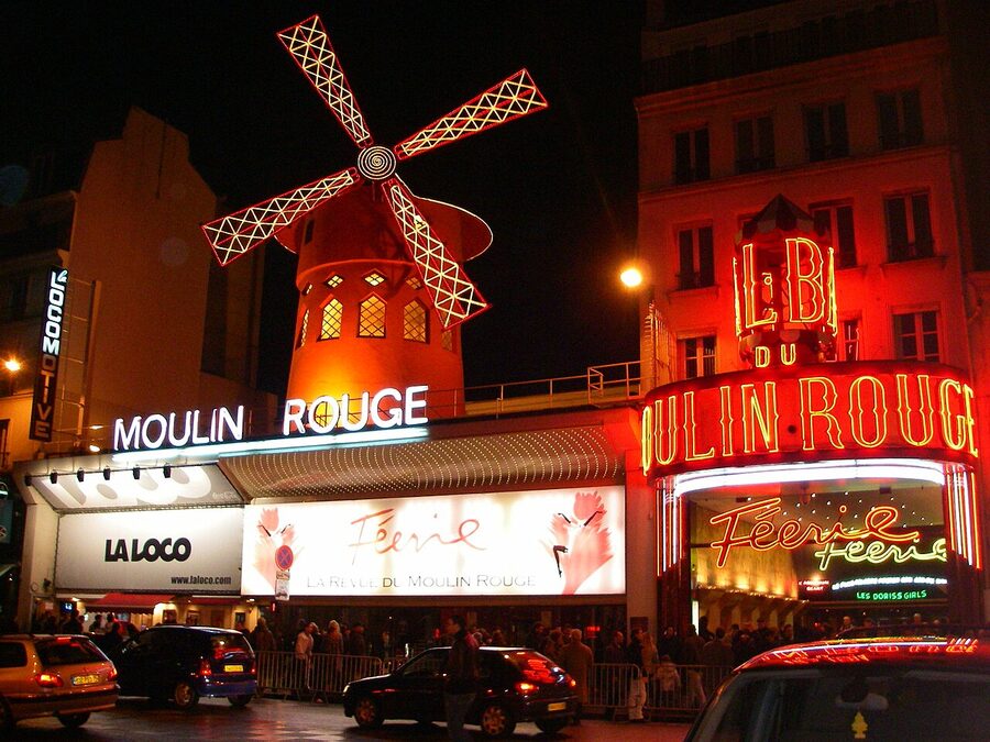 The Moulin Rouge facade illuminated at night Paris