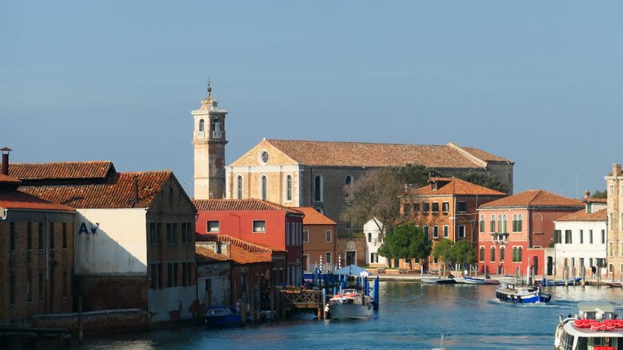 Murano Island canal with colorful buildings under clear blue sky