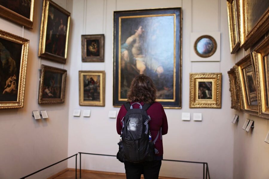 Visitor in a quiet museum gallery viewing paintings