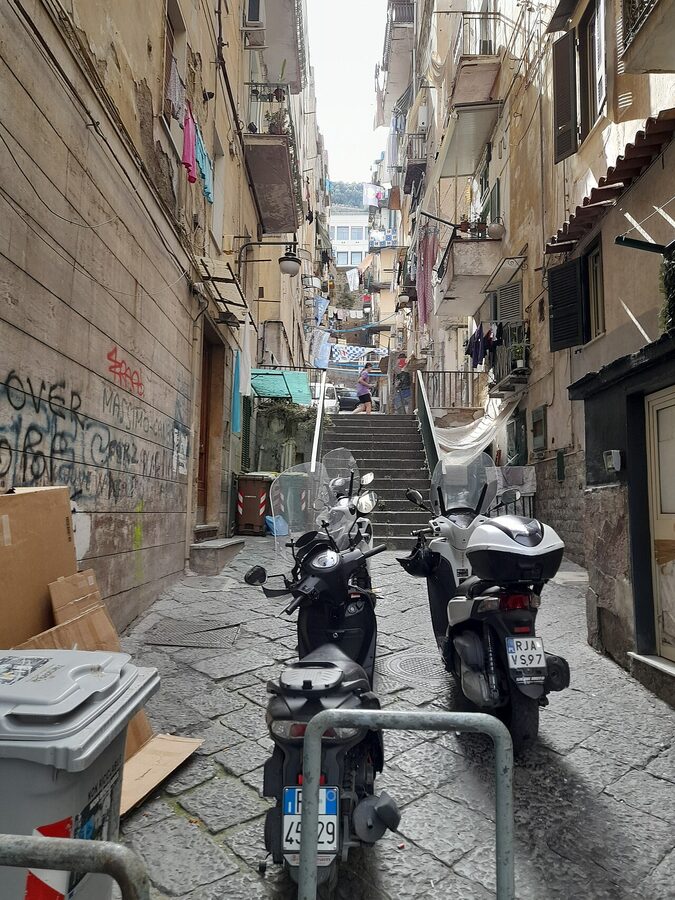 Laundry hanging across balconies in narrow Quartieri Spagnoli alley