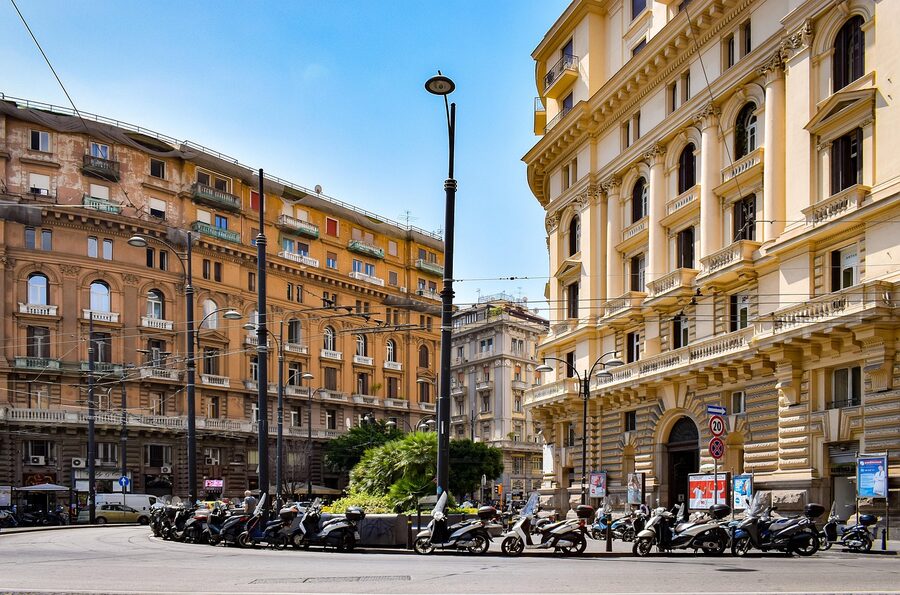 Naples street with parked scooters and tall buildings