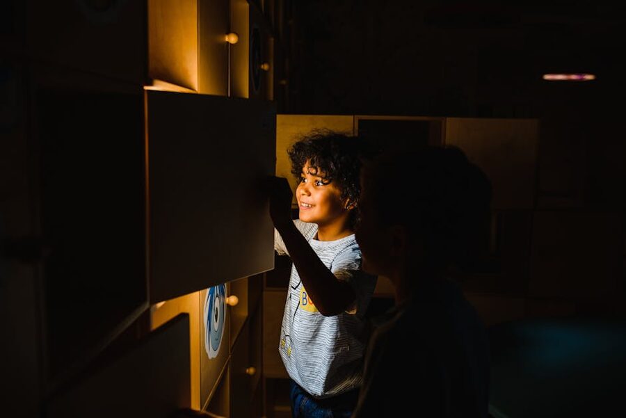Two boys engaging with a glowing educational display at a science museum