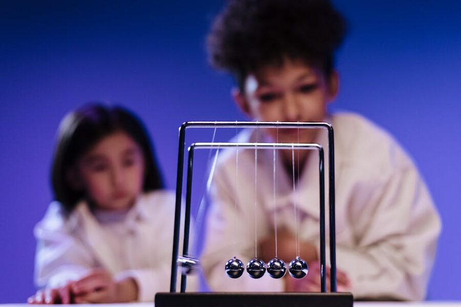 Children watching a Newtons Cradle physics demonstration at a science museum