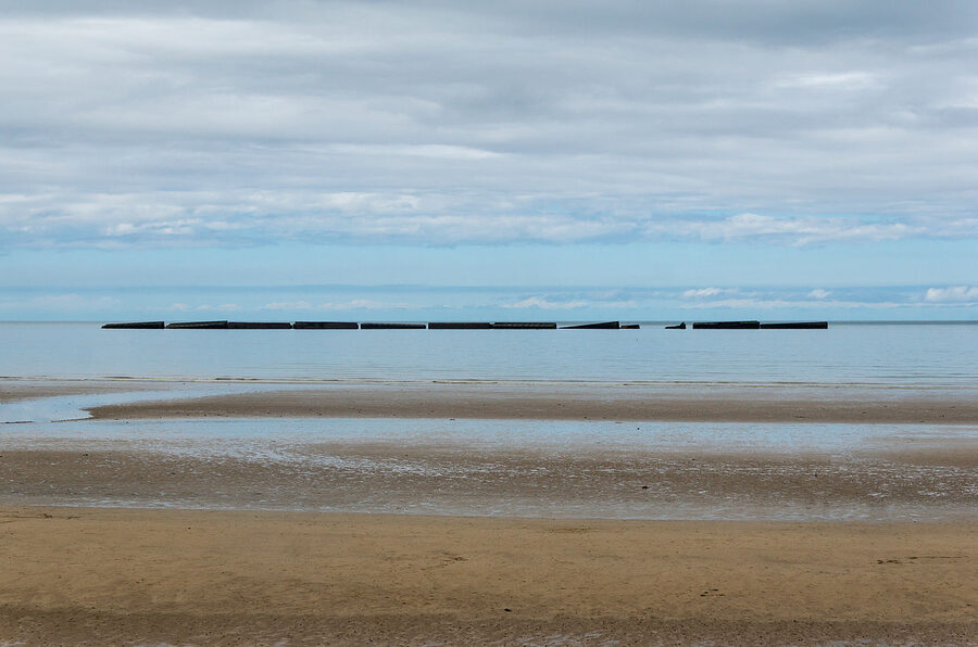 Mulberry harbour caissons visible on Arromanches beach at low tide