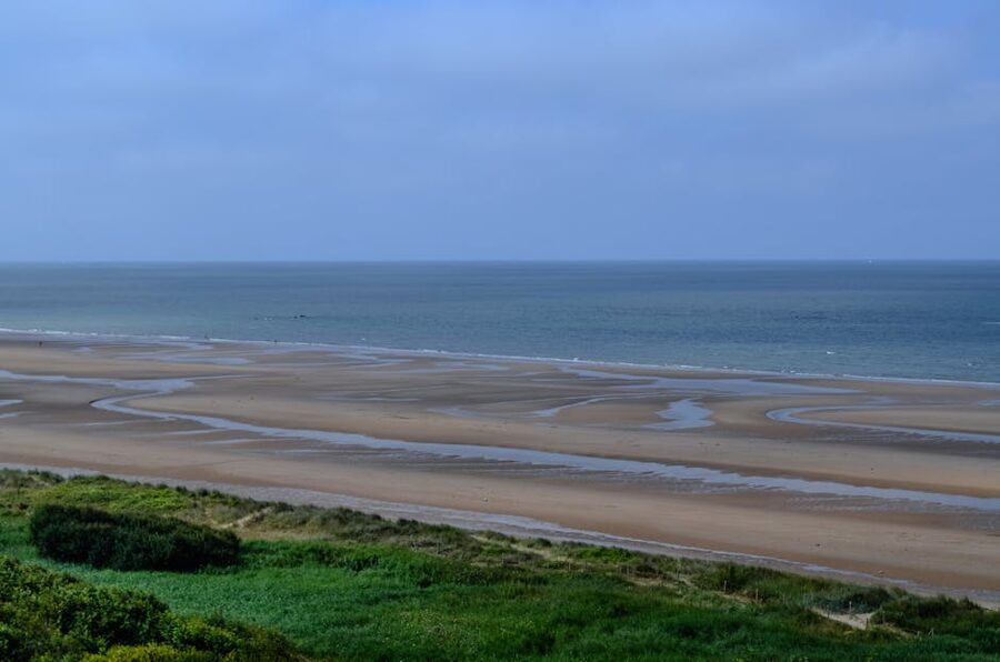 Calm sea and wide sand at Omaha Beach Normandy on a clear day