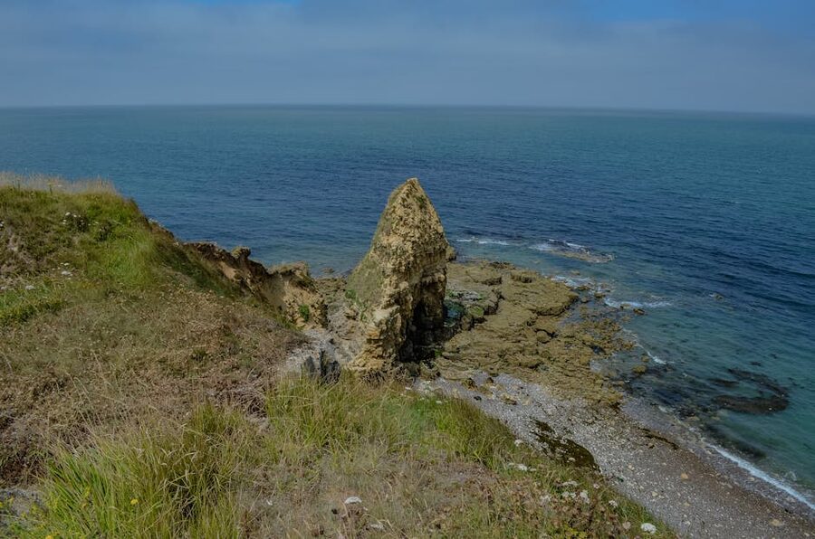 The rugged coastline at Pointe du Hoc Normandy with cliffs above the sea