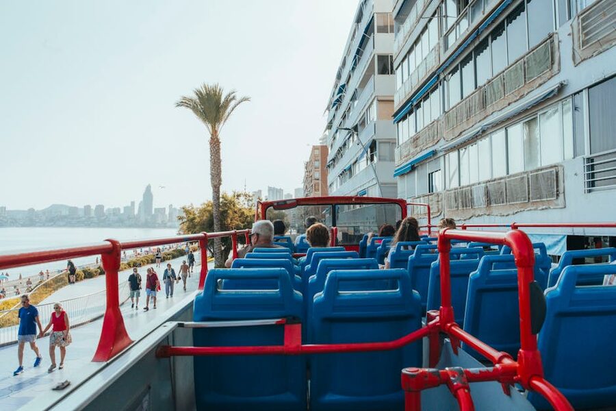 Tourists on the upper deck of an open-top bus tour