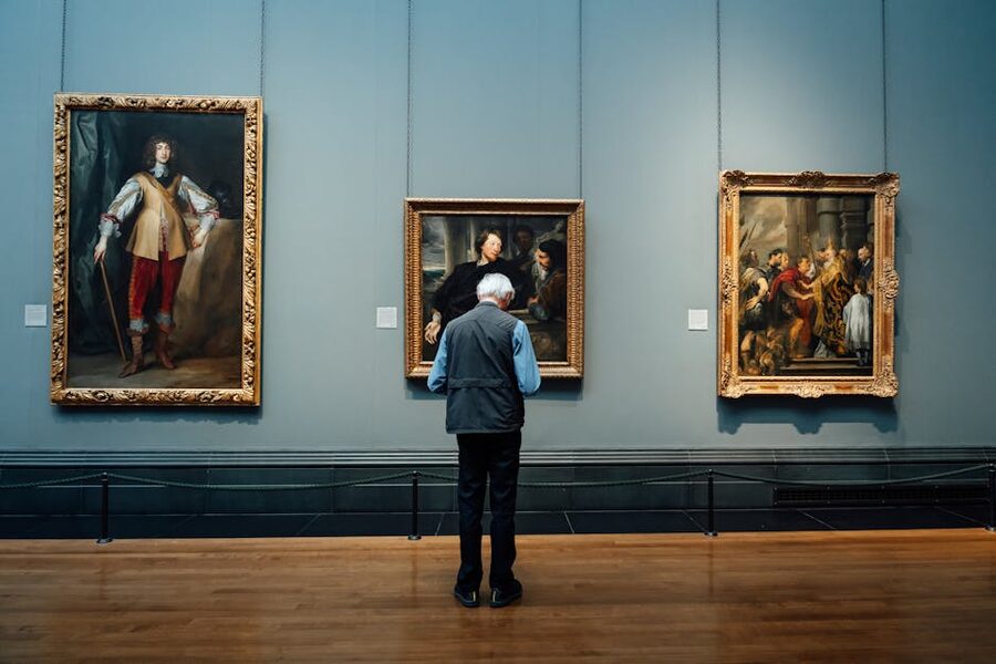 Visitor studying paintings inside an art gallery