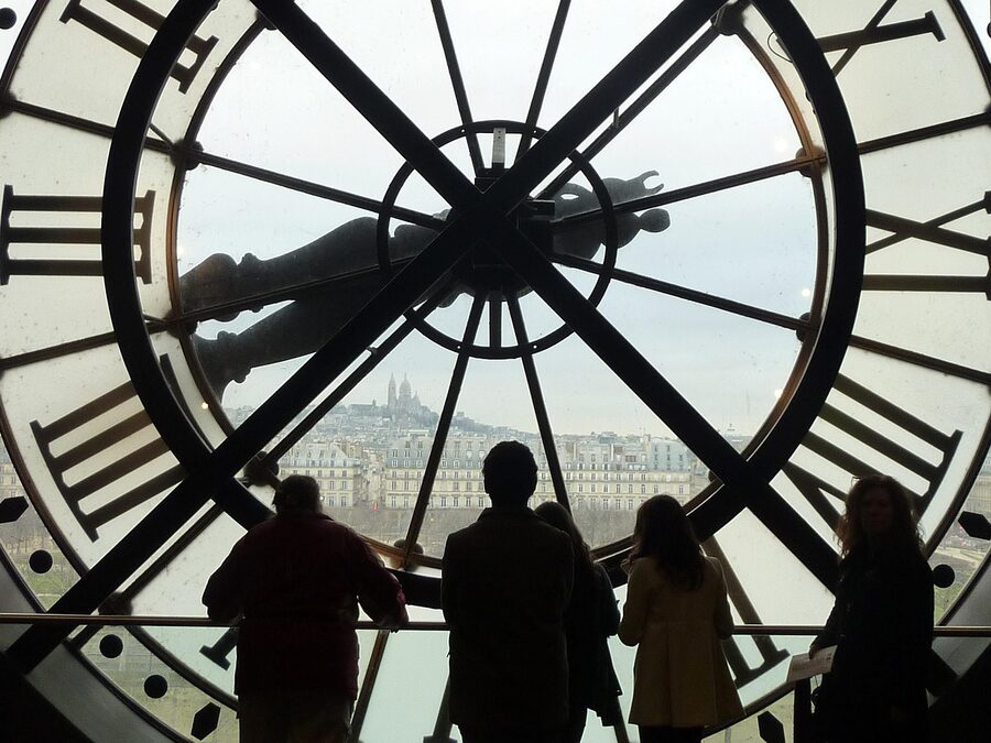 Visitors silhouetted against the famous Orsay clock window