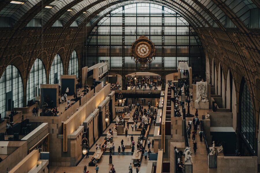 Visitors walking through Orsay Museum central nave with sculptures