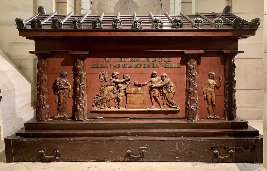 Tomb of Jean-Jacques Rousseau in the Pantheon crypt with sculpted hand holding torch