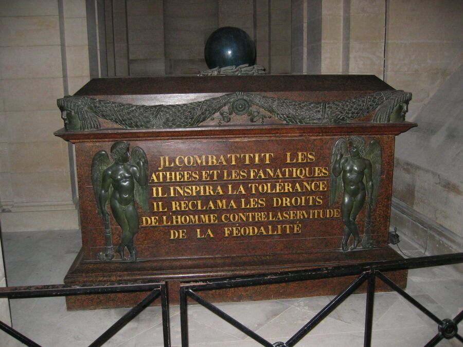 Tomb of Voltaire in the Pantheon crypt with statue holding a quill