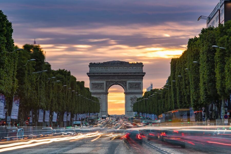 Champs-Élysées at sunset with traffic light trails towards the Arc de Triomphe