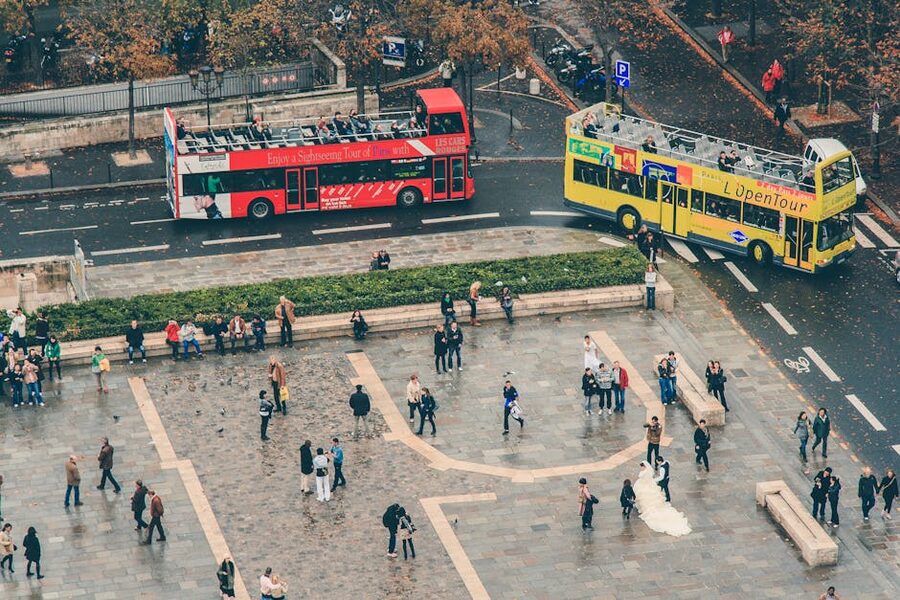 Tour buses lined up at a Paris square in autumn