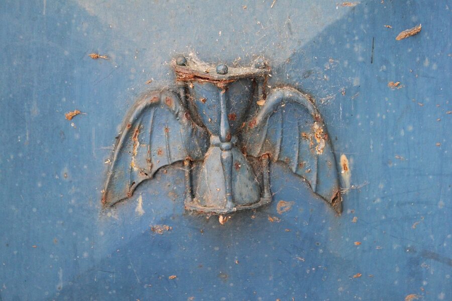 Hourglass and wing carving funerary symbol detail at Pere Lachaise Paris