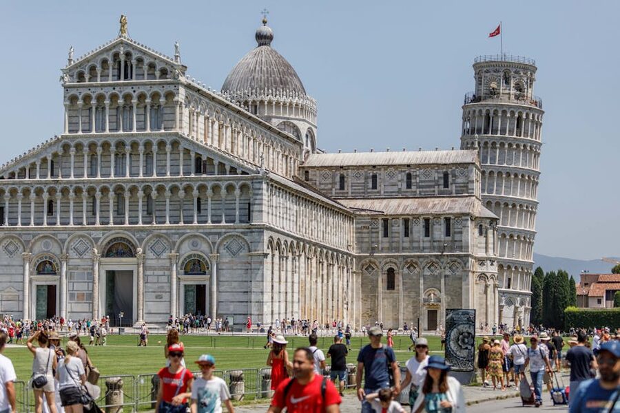 Tourists exploring Piazza dei Miracoli with the Pisa Cathedral and Leaning Tower