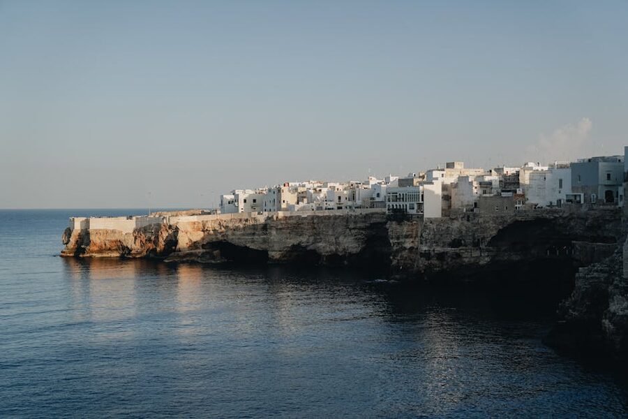 Polignano coastal buildings reflected in calm water