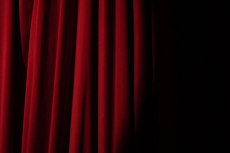 Red velvet stage curtain with dramatic lighting at a cabaret theatre