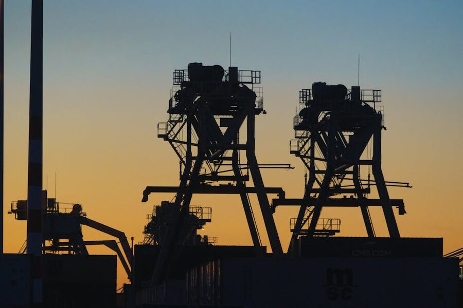 Silhouettes of harbour cranes against a sunset sky in the Port of Rotterdam