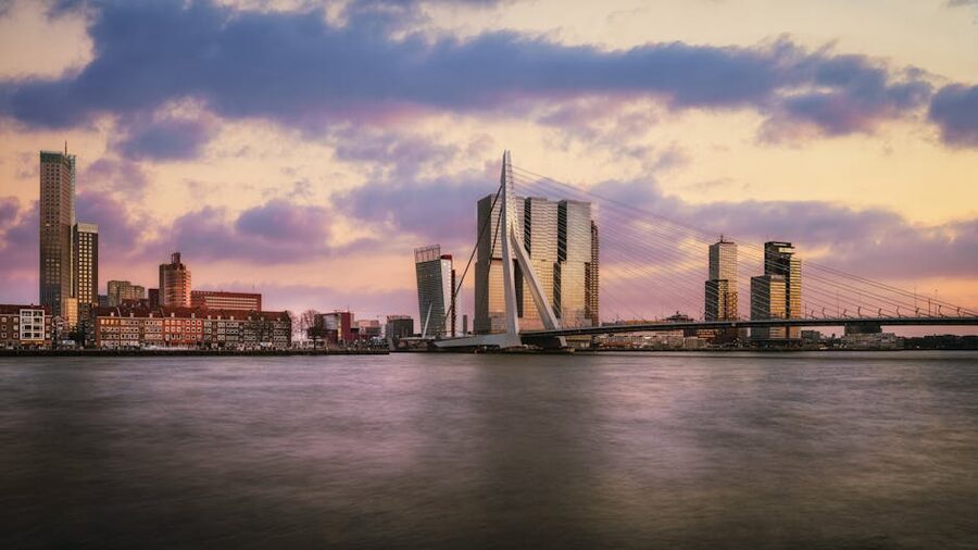 Rotterdam skyline at twilight with the Erasmus Bridge lit up over the Maas River