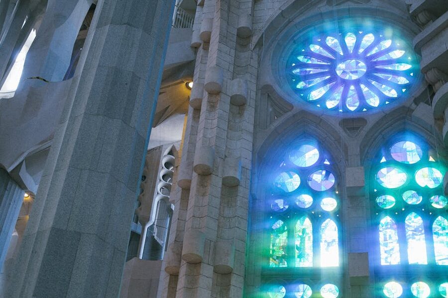 Interior of Sagrada Familia in cool blue and green light from east windows