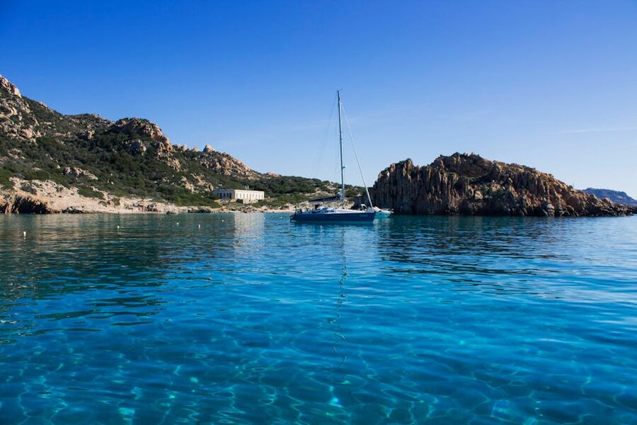 Sailboat on clear blue water La Maddalena lagoon Sardinia