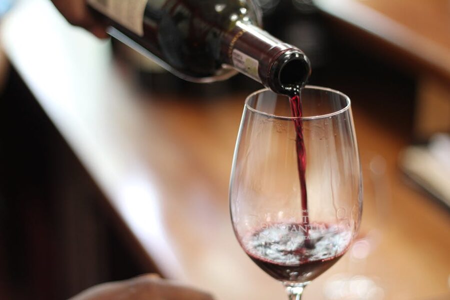 Red wine being poured into a glass at a tasting
