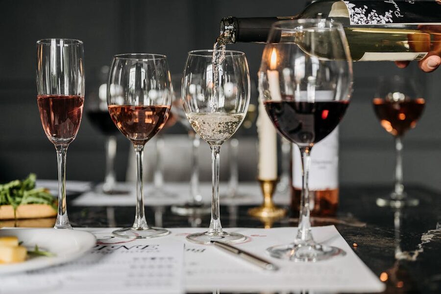 Wine tasting flight of three glasses being poured indoors