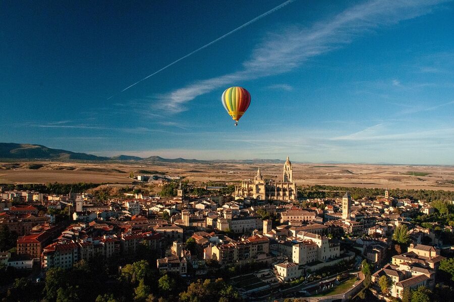 Hot air balloon over Segovia city with aqueduct visible