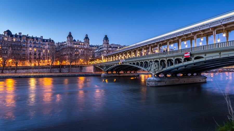 Paris bridge over the Seine river with Métro lights at night