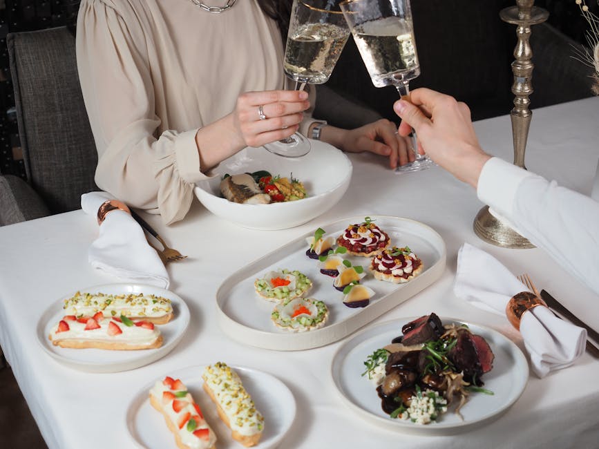 Couple toasting with champagne over a candlelit gourmet dinner table